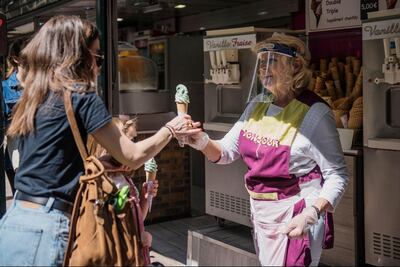 An ice cream seller wears a protective mask during the first weekend after Paris opened up after two months of strict lockdown, France, 17 May. Julien de Rosa / EPA