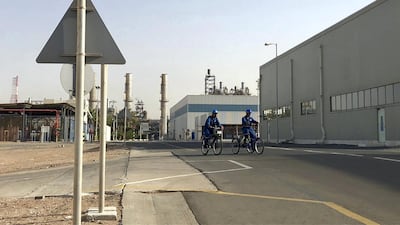 Employees of Borouge, Abu Dhabi's largest chemicals producer, cycle to work at the company's facility in Ruwais. Jennifer Gnana / The National