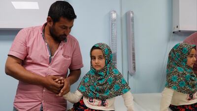 Maya's uncle, Hussein, waits with her at the clinic. Reuters