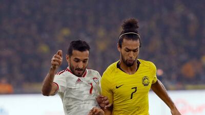 UAE's goalscoring hero Ali Mabkhout, left, holds off the challenge of La'Vere Corbin-Ong. AP