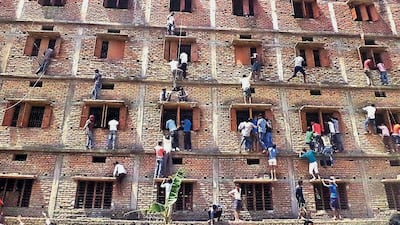 Indian relatives climb the wall of a building to help students appearing in an examination in Hajipur, in the eastern Indian state of Bihar. Even with police presence, parents and relatives are reported to scale building walls in order to pass notes to help students cheat in their exams. AP Photo / Press Trust of India