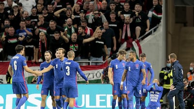 Raheem Sterling, right, celebrates scoring for England as fans in the Puskas Arena shout abuse from the stands. PA