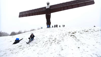 People sledge under the Angel of the North in Gateshead, England. Owen Humphreys/PA via AP