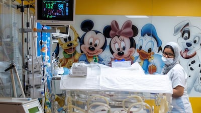 A staff member checks on one of Ms Cisse's nine babies being cared for in incubators in a Moroccan clinic. AFP