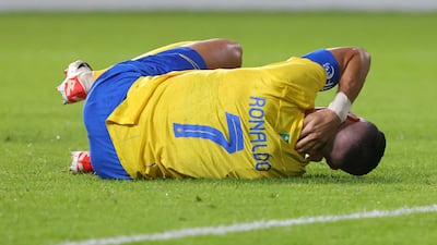 Al Nassr's Portuguese forward Cristiano Ronaldo lies on the pitch in pain after a collision with Persepolis goalkeeper Alireza Beiranvand during the AFC Champions League Group E match at the Al Awwal Stadium in Riyadh on November 27, 2023. AFP