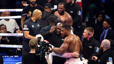 Anthony Joshua is pulled away by referee Marcus McDonnell after clashing with Jermaine Franklin and a member of Franklin's coaching staff after a heavyweight boxing match at The O2. AP