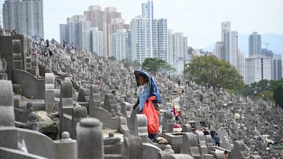 A worker cleans graves in a cemetery in Diamond Hill in Hong Kong during the Chung Yeung Festival. AFP