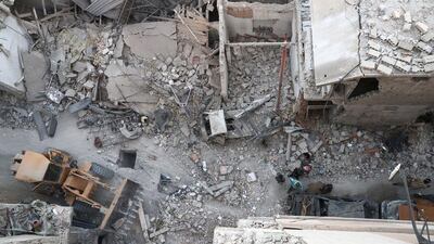 Syrians walk amid the rubble of destroyed buildings on October 3, 2016, following reported air strikes in the rebel-held town of Douma, on the eastern outskirts of the capital Damascus. Abd Doumany/AFP