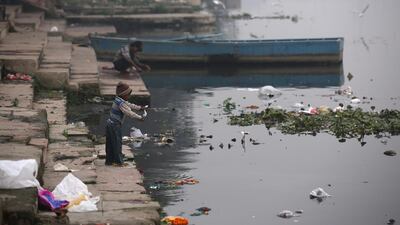 An Indian child throws materials into the polluted Yamuna river in New Delhi, India, on December 5, 2017. Rajat Gupta / EPA