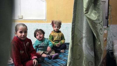 Syrian children sit at a makeshift clinic f in the rebel-held town of Douma in Syria's eastern Ghouta region. Hamza Al Ajweh / AFP