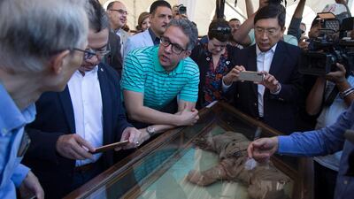 Egypt's Minister of Antiquities Khaled el-Anany, centre, said digs were uncovering 'hundreds of objects' in the area. EPA