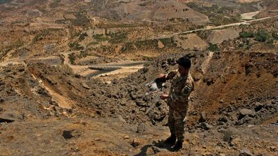 A soldier shows a fragment of a bomb in the Mahmoudiye Farms on the Khardali river in southern Lebanon, which was targeted by Israeli strikes.