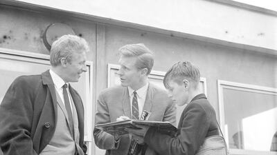 Scottish footballers Billy McNeill (centre) and Denis Law signing autographs for a young fan after their arrival at Heathrow Airport for Scotland's game against England on 8th April 1965. Getty Images