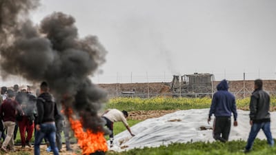 Palestinians set fire to tyres along the Gaza-Israel border east of Khan Yunis in the southern Gaza Strip. Israeli forces shot dead a Palestinian before extracting his body with a bulldozer. AFP