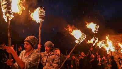 Iraqi Kurds march with torches during a procession to celebrate the Nowruz New Year festival in the town of Akre, about 100km north of Arbil. AFP
