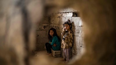 Syrian girls, displaced with their family from Deir Ezzor, look at the camera inside the damaged building where they are living in Syria's northern city of Raqqa.