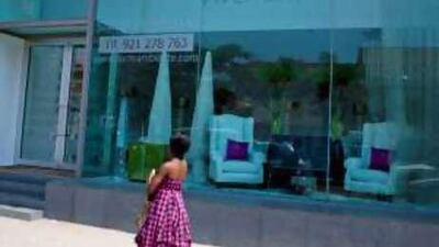 A woman walks past the showroom for the new luxury apartment building in Luanda.
