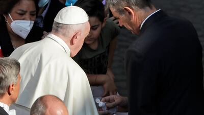 Pope Francis has his hands sanitised by his personal assistant during his weekly general audience in San Damaso courtyard at the Vatican. AP Photo