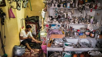 Noor Islam, from Bangladesh, strips copper wire for recycling in the small electrical and plumbing shop in which he works. Many of the old shops in the original souq of have closed but some still offer their services to customers living nearby.