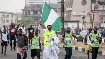 A man waves the Nigerian flag above his head during the Lagos City Marathon on Saturday. Stefan Heunis / AFP