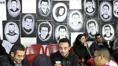 Youths pass the time in a cafe in Cairo, where paintings on the wall depict martyrs who died during the January 25 revolution. Asmaa Waguih / Reuters