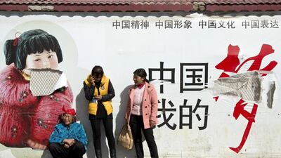 Passengers wait in front of a broken propaganda poster featuring “the China Dream” outside the Kunming Railway Station in Kunming, in western China. Alexander Yuan / AP Photo