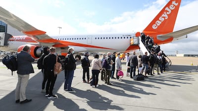 Passengers prepare to board a flight bound for Faro, Portugal, at London's Gatwick Airport. AP Photo
