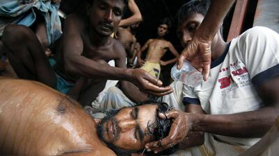 A Bangladeshi refugee is attended to after surviving a boat journey to Kuala Langsa Port in Indonesia. (Binsar Bakkara / AP)