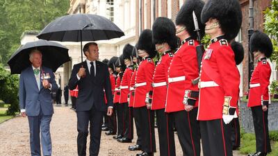 Britain's Prince Charles and French President Emmanuel Macron inspect a guard of honour from the Grenadier Guards at Clarence House in central London. AFP