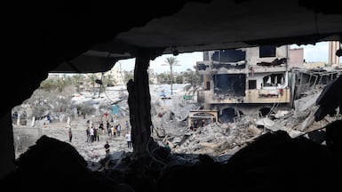 Palestinians assess the destruction of a residential building hit by an overnight Israeli strike, after a displacement warning from the Israeli military, in Deir Al Balah, central Gaza. AFP