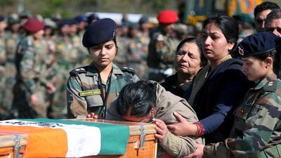 The mother of Tushar Mahajan, an Indian army officer who was killed in a gunbattle, weeps as she touches the coffin of her son Tushar during his wreath laying ceremony in Udhampur, north of Jammu, February 22, 2016. Mukesh Gupta/Reuters