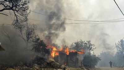 A building burns as fire rescue workers try to extinguish a fire in the hills around the town of Boutchay in Baabda, east Beirut, Lebanon. Wael Hamzeh / EPS