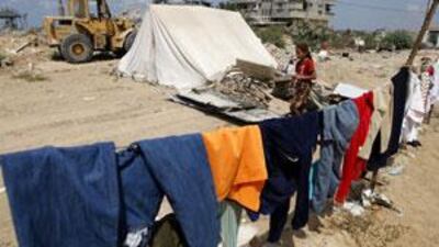 A Palestinian girl walks past a tent next to the remains of their house which was destroyed during Israeli's January offensive, in Gaza City.