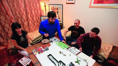 Game on: left to right, Alesya Katyuk, Omar Ismail, Tarek Omar and Thomas Martin – all members of the highly social, 220-person-strong Gulf Roleplaying Community – get down to role-playing business in Abu Dhabi. Sarah Dea / The National