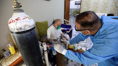 Osama Mohammad, an Iraqi nurse who volunteers to take care of coronavirus patients in their homes, provides medical care to 68-year-old Majeed Allaw at his house in Baghdad. EPA