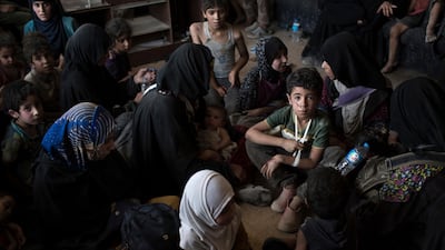 Fleeing Iraqi civilians sit inside a house as they wait to be taken out of the Old City during fighting between Iraqi forces and Islamic State militants in Mosul, Iraq, Saturday, July 8, 2017. (AP Photo/Felipe Dana)