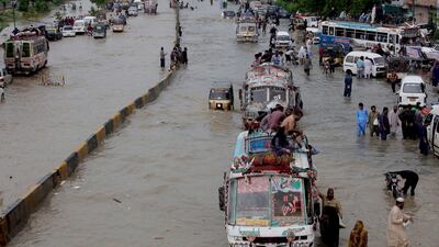 Vehicles drive through a flooded road after heavy monsoon rains, in Karachi, Pakistan. AP