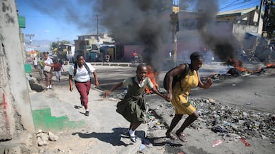 People flee as protesters and police clash in Port-au-Prince, Haiti. AP