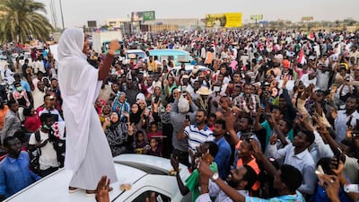 Alaa Saleh speaks to protesters from the top of a car. AFP