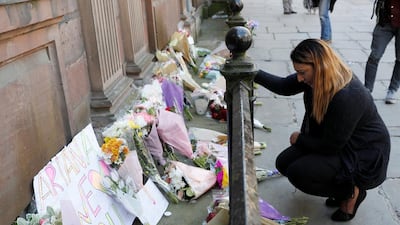 A woman lays flowers for the victims of the Manchester Arena attack, in central Manchester, Britain May 23, 2017. REUTERS/Darren Staples