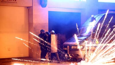Police officers protect themselves from a flare on the Champs Elysees avenue after PSG won the Champions League. Reuters