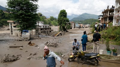 Villagers wade through flooded streets in the aftermath. EPA