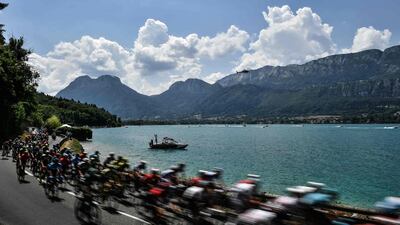 Cyclists ride along the lake of Annecy during the 10th stage of the Tour de France between Annecy and Le Grand-Bornand. Jeff Pachoud / AFP