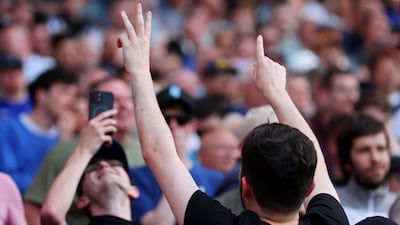An Arsenal fan signals that Manchester City are beating West Ham 3-1. Getty Images