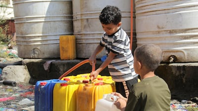 Boys fill cans with drinking water from a tank in Taiz, Yemen. Reuters
