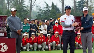 Tiger Woods looks on as Rory McIlroy receives his trophyfor winning the Duel at Jinsha Lake