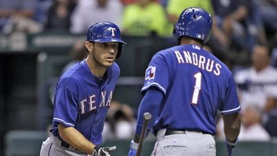 Ian Kinsler, left, hit a crucial home run for the Rangers against the Rays. Chris O'Meara / AP Photo