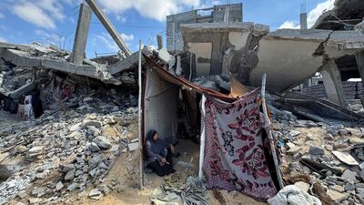A Palestinian woman shelters in a makeshift tent in the rubble of a house destroyed in Israel's military offensive in Khan Younis, southern Gaza. Reuters