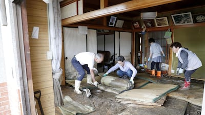 Local residents try to clean inside a house at an area flooded by Typhoon Hagibis in the town of Marumori, Miyagi prefecture, Japan. REUTERS