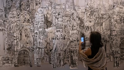 A woman takes a photo of an exhibit at Art Dubai. Antonie Robertson / The National